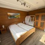 Bedroom with double bed, crib, and wooden walls