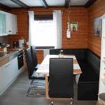 Kitchen with dining area and wooden walls. Table with chairs and sofa.
