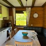 Kitchen with dining area, wooden walls, window, and table with chairs.