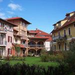 Haus mit Garten und Balkonen unter blauem Himmel