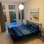 Schlafzimmer mit Bett, Fenster und Wandbild.