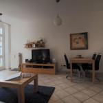 Wohn- und Essbereich mit TV, Esstisch und Fenster zur Außenterrasse.