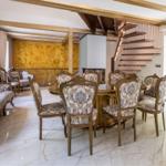 Esszimmer mit goldenem Tisch, Stühlen und Sofa. Hintergrund: goldene Wand und Treppe.