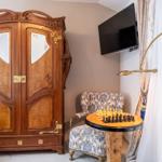 Ein Raum mit einem großen Schrank, einem Sessel und einem Schachbrett auf einem Tisch.