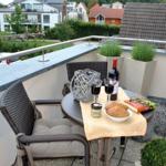 Balkon mit Tisch, Stühlen und Blick auf Wohngebiet.