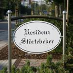Schild mit der Aufschrift Residenz Störtebeker in einem Gartenbereich.