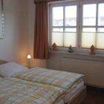 Zimmer mit Doppelbett, Fenster und Lampe