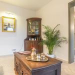 Wohnbereich mit Ledersofa, Holzkommode und Blick in die Dusche