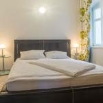 Schlafzimmer mit Doppelbett, zwei Nachttischen und Spiegel an der Wand.