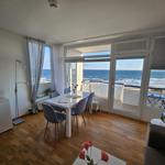 Esszimmer mit Meerblick und Balkon. Holzboden und weiße Möbel.