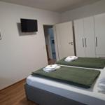 Schlafzimmer mit Doppelbett, Kleiderschrank und Wand-TV.