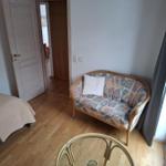 Wohnraum mit Sofa, Tisch und Tür zum Flur.