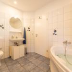 Badezimmer mit Badewanne, Toilette und Waschbecken.