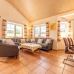 Wohn- und Essbereich mit Sofa, Sessel, Tisch und Küchenzeile.