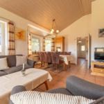 Wohn- und Essbereich mit Sofa, TV und Esstisch. Holzdecke und Terrakottaboden.