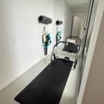 Fitness room with mat, exercise equipment, and wall mounts.