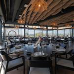 Large dining room with tables, chairs, and large windows.