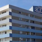 Fünfgeschossiges Wohngebäude mit Balkonen und blau-weißem Fassadendesign.