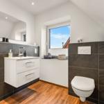 Badezimmer mit Waschbecken, Toilette und Fenster mit Blick.