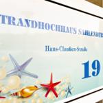 Schild für Strandhochhaus Sahlenburg, Hans-Clauben-Straße 19 mit Meeresmotiven.