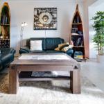 Ein Wohnzimmer mit zwei Ledersofas, einem Holztisch und Bootsbüchern an den Wänden.