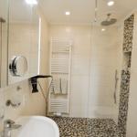 Badezimmer mit Dusche, Spiegel und Heizkörper