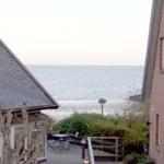 Meerblick zwischen zwei Gebäuden mit Terrasse und Gartenbereich.