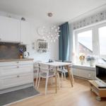 Küche mit Esstisch, TV und Fenster mit Blick nach draußen.