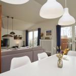 Wohn- und Essbereich mit Sofa, Esstisch und Balkonansicht.