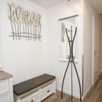 Eingangsbereich mit Spiegeln, Sitzbank und Wanddekoration.