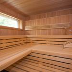 Holzsauna mit Sitzbänken und Fenster zur Außenseite.
