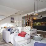 Wohnbereich mit Sofa, Couchtisch und Küche im Hintergrund.