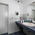 Badezimmer mit Waschbecken, Spiegel und Handtuchhalter