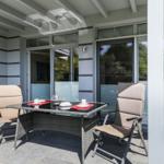 Terrasse mit Tisch und zwei Stühlen unter Dach