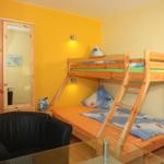 Ein Schlafzimmer mit einem Holzbett, einem Kleiderschrank und einem schwarzen Sessel.