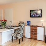 Essbereich mit Tisch, Stühlen und Fernseher an der Wand.