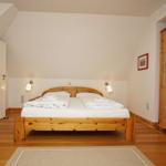 Schlafzimmer mit Holzbett, Kleiderschrank und Holzboden.