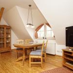 Esszimmer mit Holztisch, Stühlen und TV-Schrank unter schrägem Dach