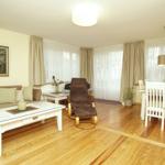 Wohn- und Essbereich mit Holzboden, Sofa, Esstisch und Sessel.