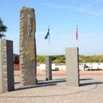 Steinsäulen mit Beschriftung und Flaggen im Freien