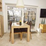 Esszimmer mit Holztisch, Stühlen und Blick auf Außenbereich.