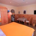 Ein Schlafzimmer mit Bett, Schreibtisch, Tisch mit Stühlen und Fernseher an der Wand.