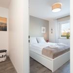 Schlafzimmer mit Doppelbett, Fenster und Wandbild. Flur mit Stuhl und Wandbild.