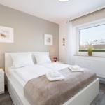 Schlafzimmer mit Doppelbett, Fenster und Nachttischen.