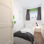 Ein Schlafzimmer mit einem Bett, einem Fenster und einer Tür.