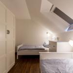 Zwei Betten, Schrank und Dachschräge mit Dachfenster.