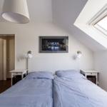 Schlafzimmer mit Doppelbett, zwei Nachttischen und Dachfenster.