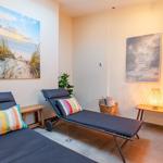 Zwei Liegestühle mit Kissen, Wandbilder und eine Lampe.