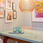 Esstisch mit zwei Stühlen, Wandbilder und einer Lampe über dem Tisch.