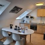 Küche mit Esstisch, zwei Dachfenstern und hellen Holzmöbeln.